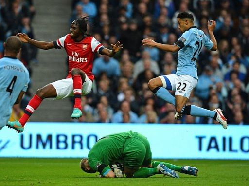 Manchester City's goalkeeper Joe Hart (ground) saves from Arsenal's Gervinho (Top L)